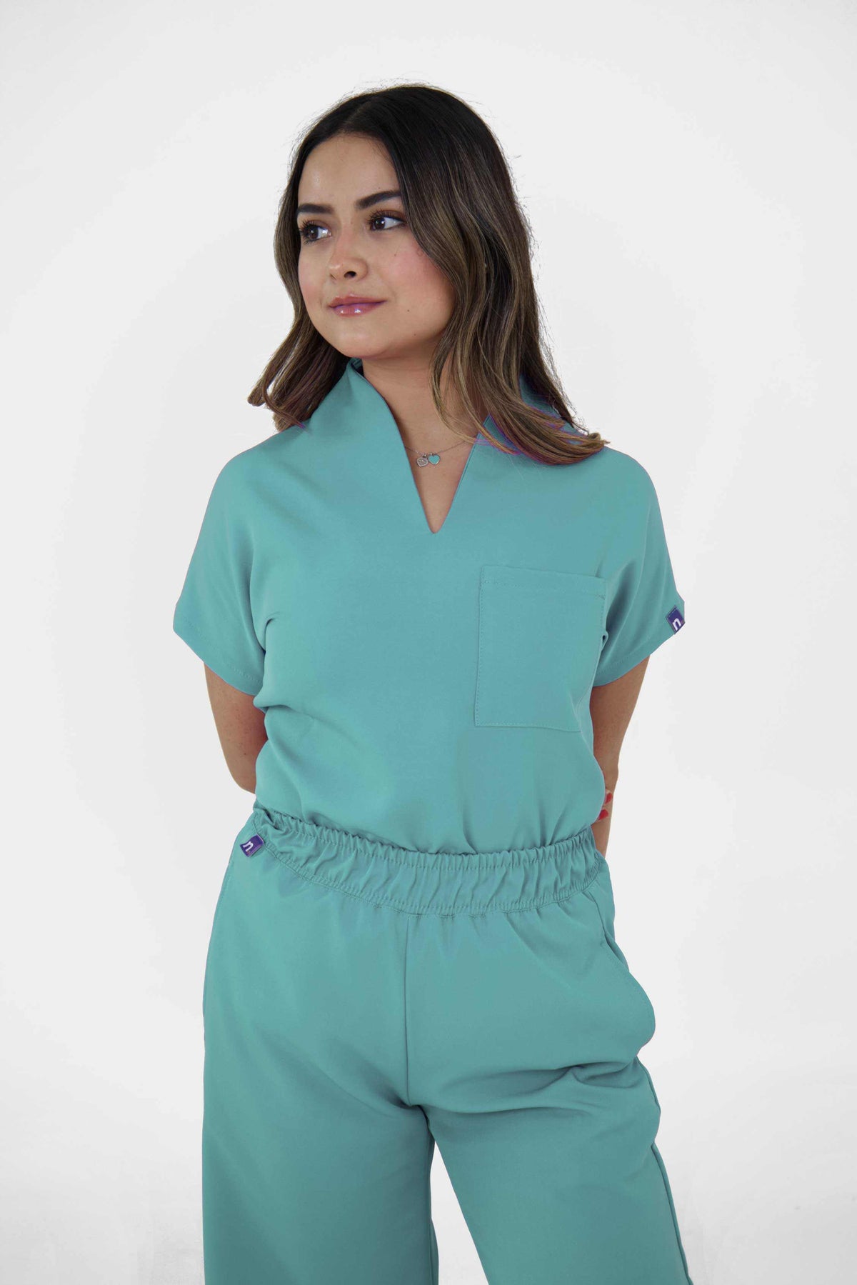 Modelo con uniformes quirúrgicos Milan elegantes, filipina con cuello en V y pantalón ancho con bolsas